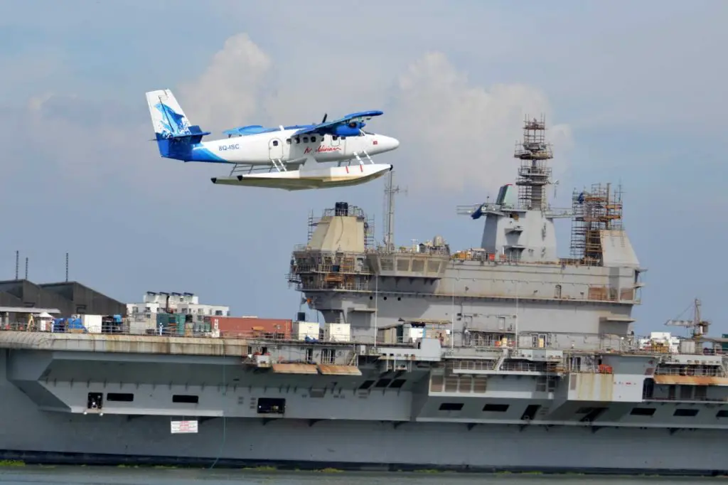 Maldivian Seaplane takes off from Venduruthy channel in Kochi with INS Vikrant in background