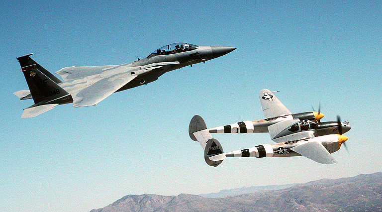 A US Air Force (USAF) F-15D Eagle aircraft (left), from the 1st Fighter Wing (FW), flies in formation with a restored World War Two (WWII) era P-38 Lightning aircraft over the Arizona desert during a USAF Heritage Conference 2002 training flight. 