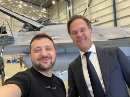 Ukrainian President Volodymyr Zelensky takes a selfie with F-16 in background